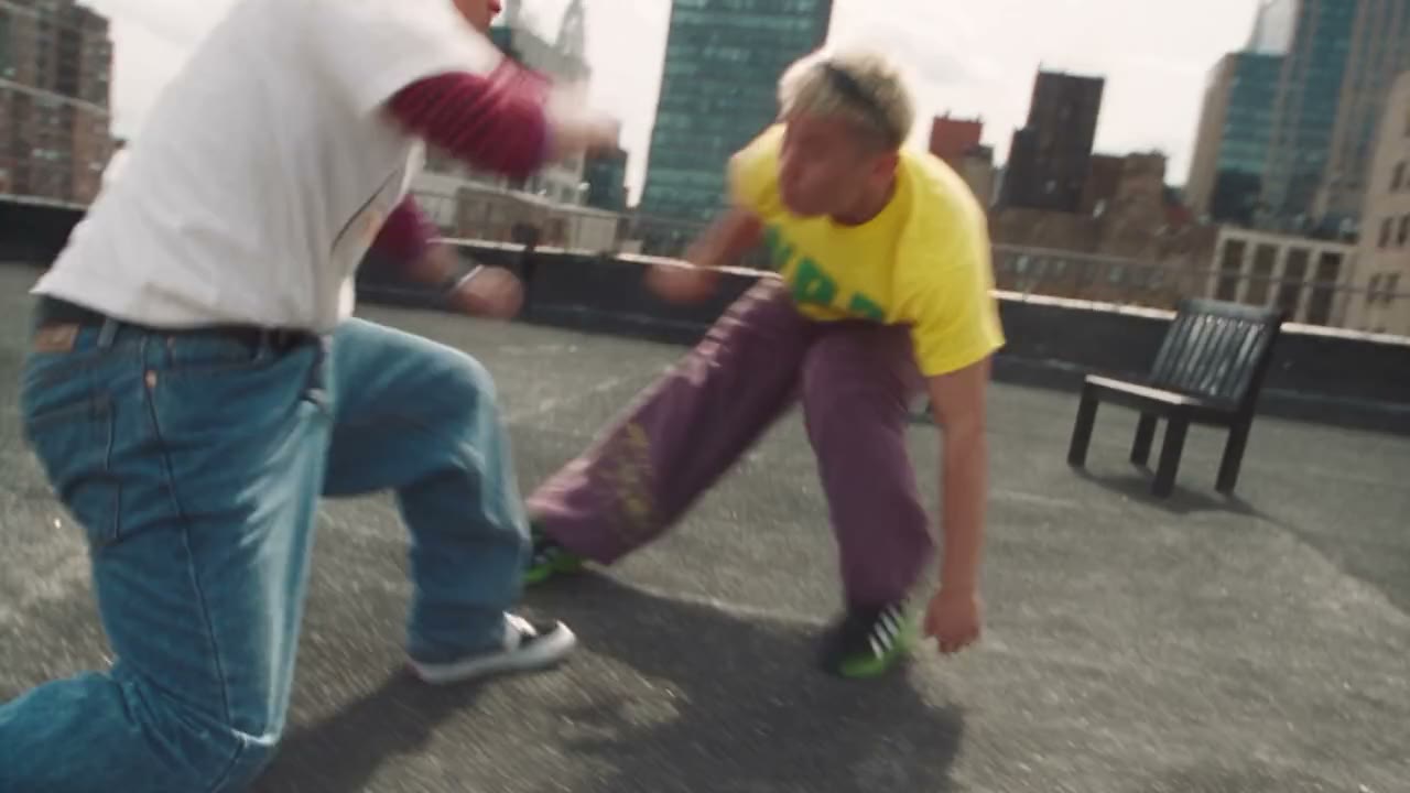 Athletes sparring on a New York rooftop that becomes a pastel dreamscape of pink hills